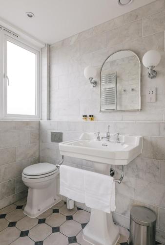 a white bathroom with a sink and a toilet at Tyndall Villa Boutique B&B in Bath