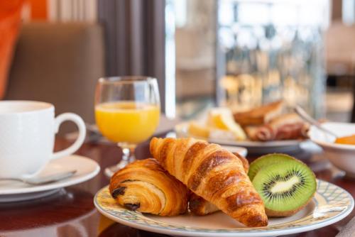 a plate of croissants and kiwis on a table at Hôtel France d'Antin Opéra in Paris