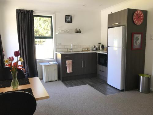 a kitchen with a white refrigerator and a window at Arches in Twizel