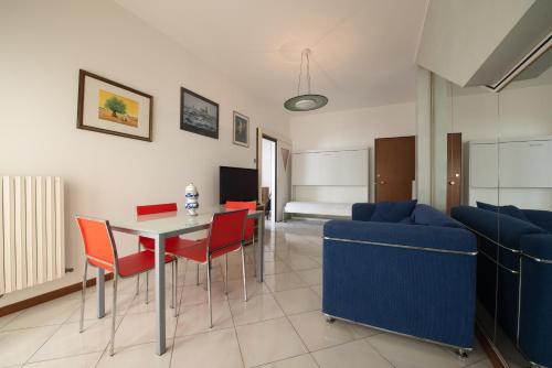 un soggiorno con divano blu, tavolo e sedie di Residence Palazzo Gasparroni a Tortoreto