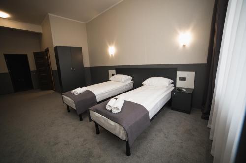two beds in a hotel room with white sheets at GOLDEN RING in Ternopilʼ