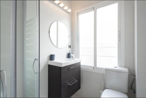 a bathroom with a sink and a mirror and a toilet at Alemania & SOHO by ELE Apartments in Málaga