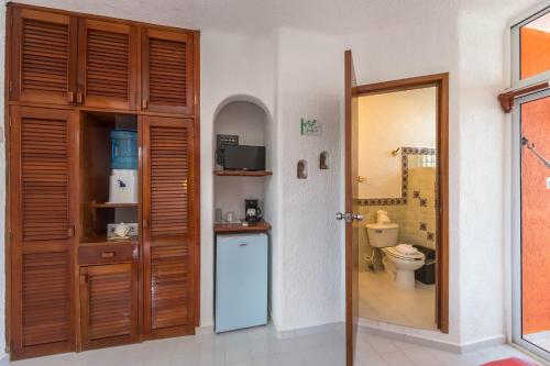 a bathroom with a toilet and a door to a room at Del Sol Beachfront in Akumal