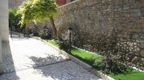 a stone wall with a lamp next to a sidewalk at Altavilla Holiday House in Tivoli