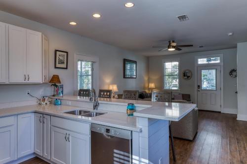 a kitchen with white cabinets and a sink at Barefoot Cottages #C56 in Highland View