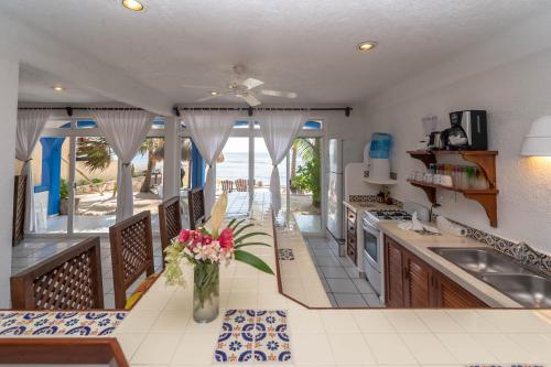 a kitchen with a vase of flowers on a counter at Del Sol Beachfront in Akumal
