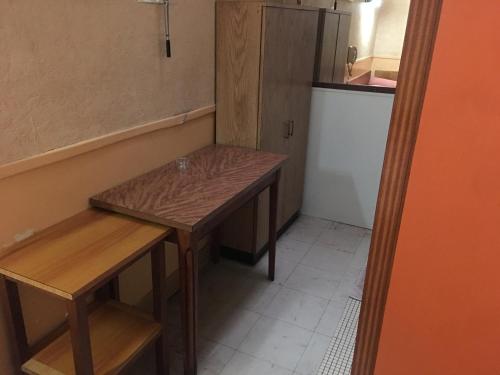 a small kitchen with a table and a refrigerator at A la Pinte du Nord in Paris