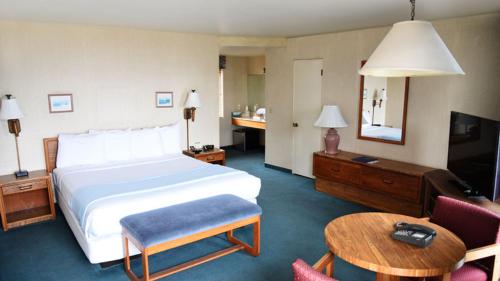 a hotel room with a large bed and a table at Cabrillo Inn at the Beach in Santa Barbara