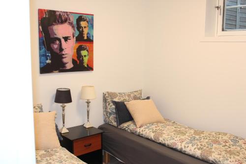 een slaapkamer met een bank en een schilderij aan de muur bij Bullseye Kristiansand in Kristiansand