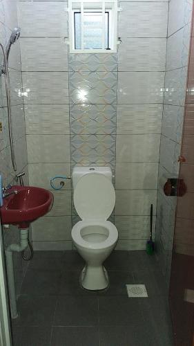 y baño con aseo y lavabo rojo. en Dhia Irdina Homestay, en Paya Rewak