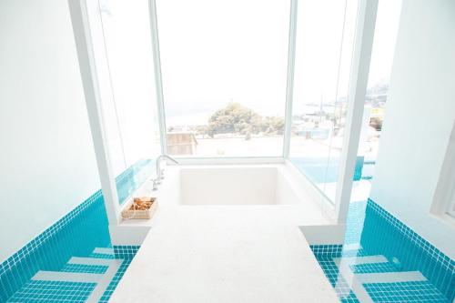 a bath tub in a room with a large window at Ample Villa 小希臘民宿 in Ruifang