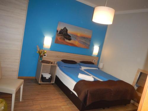 a bedroom with a bed with a blue wall at Garni Villa Betty in Merano