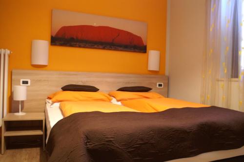 two beds in a bedroom with orange walls at Garni Villa Betty in Merano