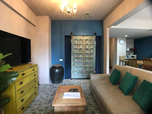 a living room with a couch and a tv at 8th House @ center of Chiangmai old town in Chiang Mai