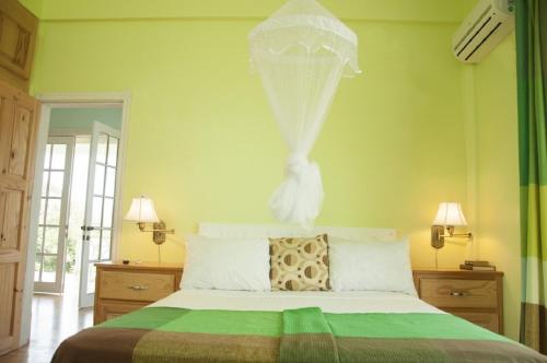 a bedroom with a bed with a veil on it at Diamond View Cottages in Roseau