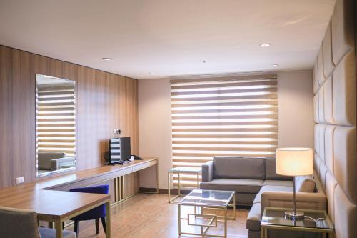 a living room with a couch and a table at La Maja Rica Hotel in Tarlac