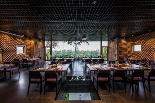 a restaurant with tables and chairs and a large window at Chicland Boutique Danang Beach Hotel in Da Nang