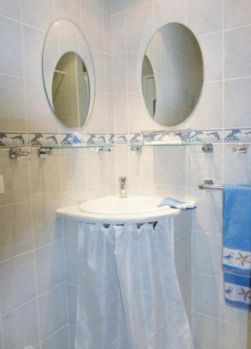 a bathroom with a sink and two mirrors at Halte Dodo in Tallard