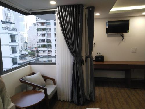 a room with a window with a desk and a television at DORADO HOTEL in Nha Trang