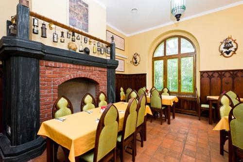 a dining room with tables and chairs and a fireplace at Havířská bouda in Kutná Hora