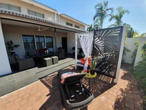 a patio with a chair in front of a house at 4 BDR Gardens Escape Inner City Townhouse with Secure Parking and Spa in Darwin