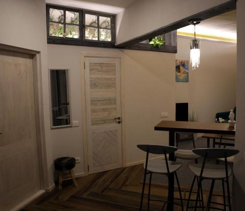 - une salle à manger avec une table et des tabourets dans l'établissement DP Art Residence - self check in, à Kaunas
