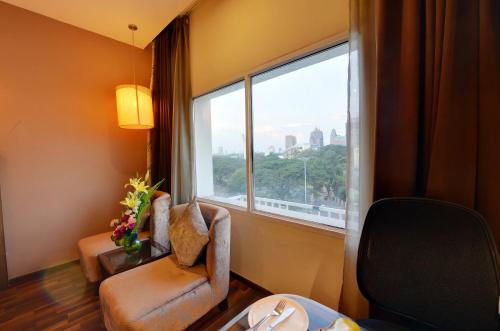 a room with two chairs and a large window at Hotel Ramanashree Richmond in Bangalore