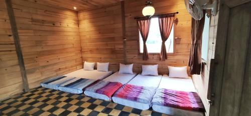 a bedroom with a bed in a wooden room at The Cabin Bungalow in Bedoyo