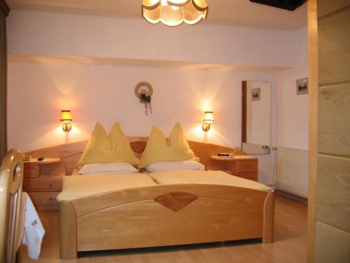 Un dormitorio con una gran cama de madera con almohadas amarillas. en Bauernhof Haim, en Pichl bei Aussee