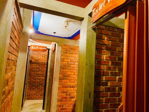 a hallway of a building with a brick wall at Vu's Homestay in Phong Nha