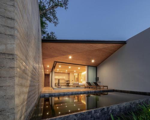 - une vue extérieure sur une maison avec une piscine dans l'établissement Tara Villa, à Kanchanaburi