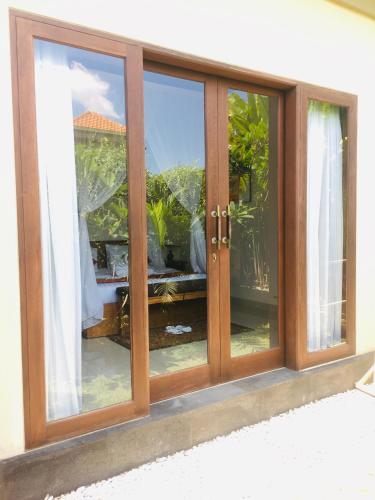 a sliding glass door with a view of a garden at Heaven Villa Ubud in Ubud