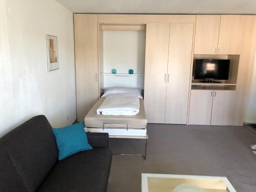 a small living room with a couch and a bed at Studio Ravaisch in Davos