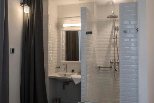 a bathroom with a sink and a shower at Appart'Hôtel - VILLA CÔTÉ PLATEAU - Hyper Centre - 3 Étoiles Certifiées- in Angoulême