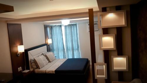 um pequeno quarto com uma cama e uma janela em Abreeza Place Tower1 by Chriza em Davao