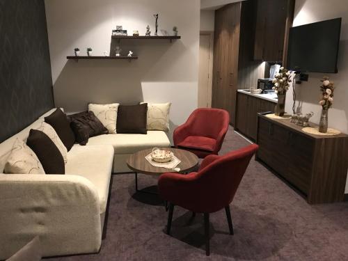 un soggiorno con divano bianco e sedie rosse di Joy Apartman Kula Konaci a Kopaonik