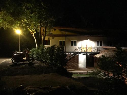 a house at night with a motorcycle in front of it at HomeHostel in Ko Chang