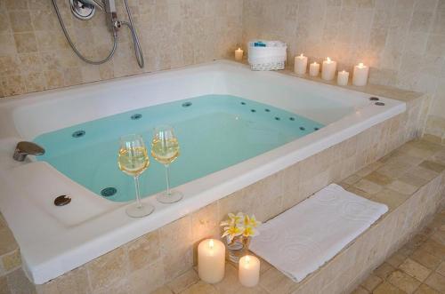 a bath tub with two wine glasses and candles at Above the Sea in Ein Hod