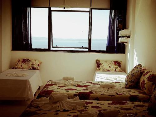 a room with two beds and a window at Sol Victoria Marina Lofts in Salvador