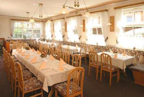 a banquet hall with tables and chairs and windows at Blaue Grotte & Frankenhotel in Debring