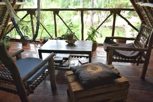 una stanza con sedie, tavolo e amaca di Lazy Beach House a Kiwengwa