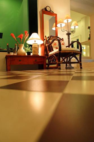 a living room with a chair and a mirror at The Terrace Hotel in Nakhon Si Thammarat