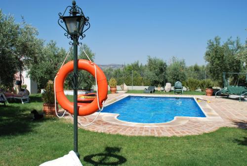 una piscina con un anillo naranja alrededor en Agroturismo Ecologico el Cortijillo en Luque