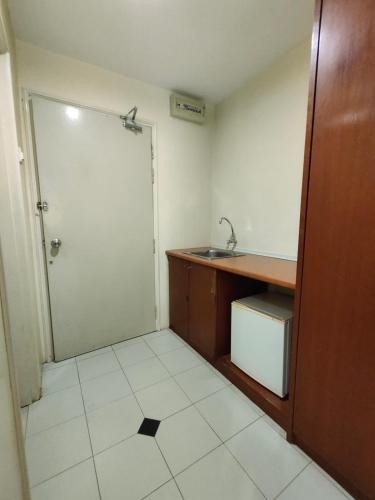uma pequena casa de banho com um lavatório e uma porta em Wawa's Golf View Inn em Taiping