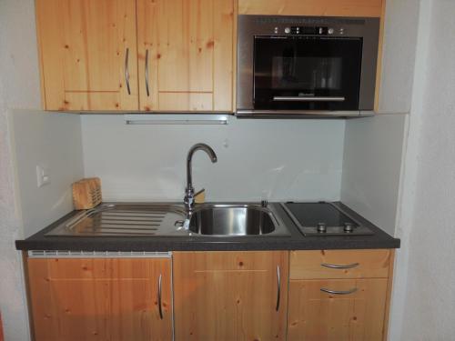 a kitchen with a sink and a microwave at Lona C 43 in Grimentz