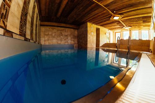 an indoor swimming pool with blue water in a building at Cool Studio - Apartment in Gosau - Hallstatt - Wellness and Pool included in Gosau