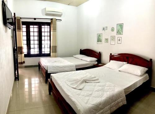 um quarto com duas camas e uma janela. em Anh Xuan Guest House em Hue