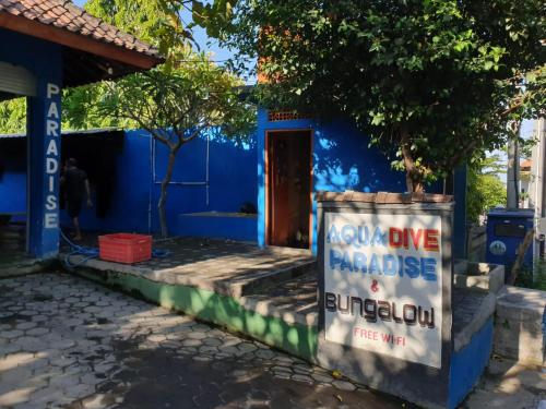 a blue house with a sign in front of it at Aqua Dive Paradise in Tulamben