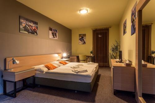 een slaapkamer met een bed en een bureau en een bed sidx sidx sidx bij Penzion ER1 in Zlín