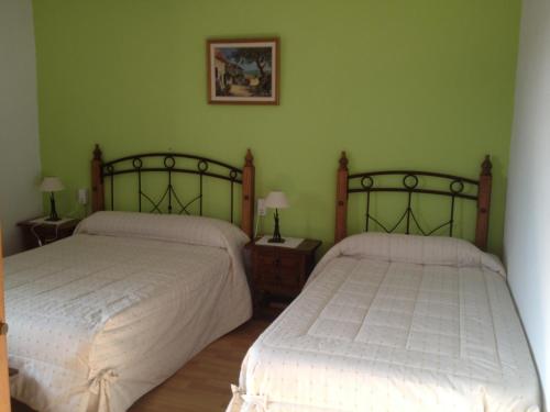 two beds in a bedroom with green walls at Mas Vell in Catí